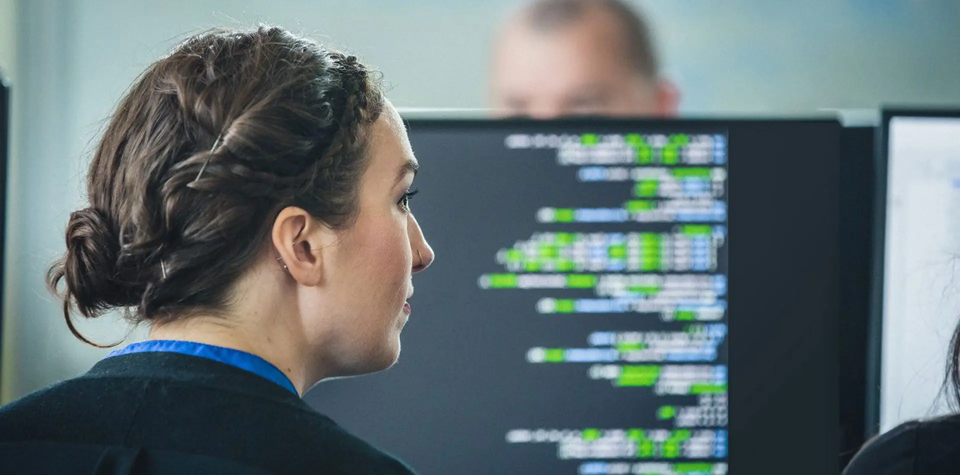Woman looking at computer screen with code.