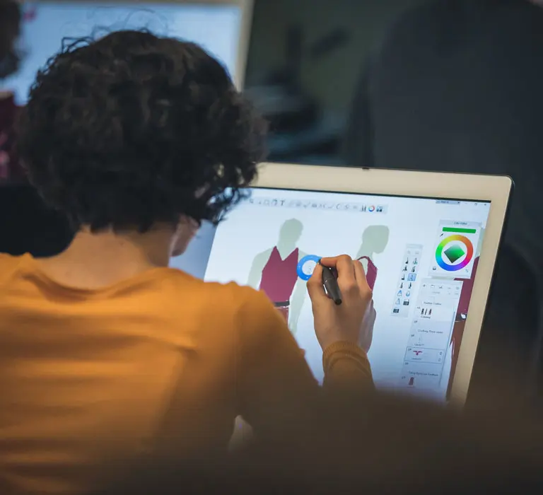Regent University animation student drawing on a computer
