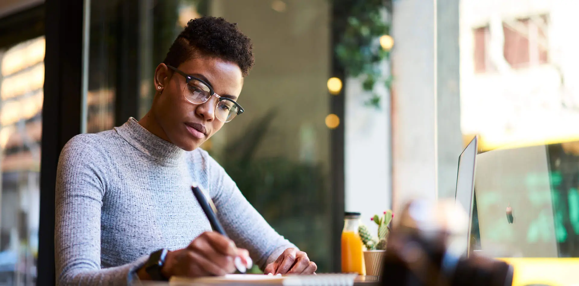 Regent student wearing glasses writing