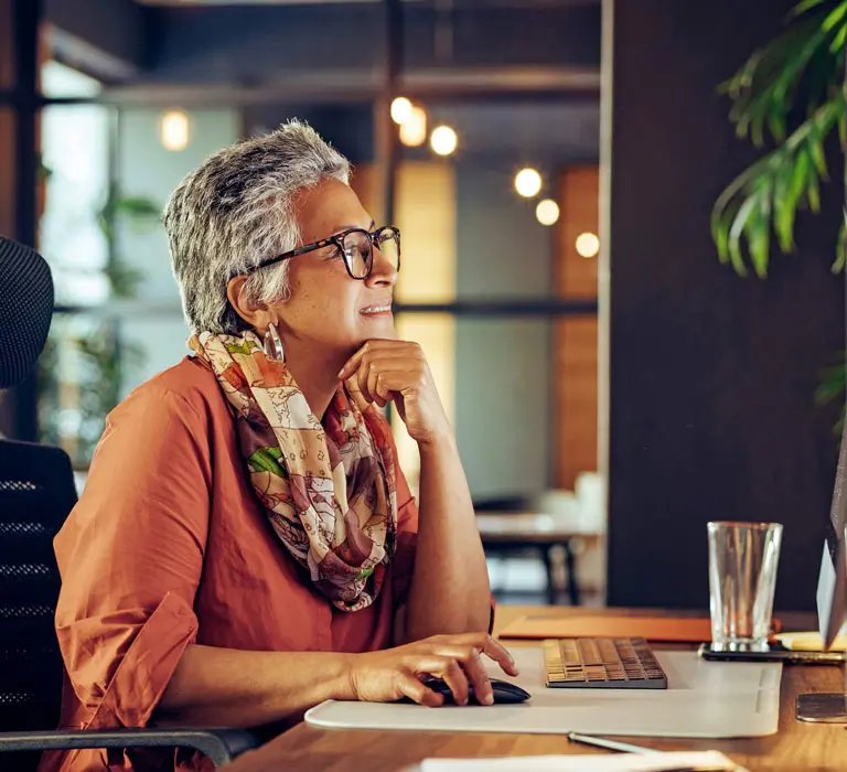 Woman in glasses with computer at desk